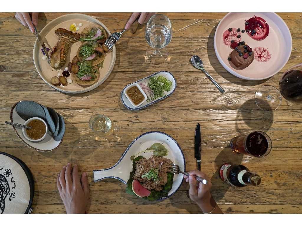 mesa con platillos y vino del restaurante Tamayo