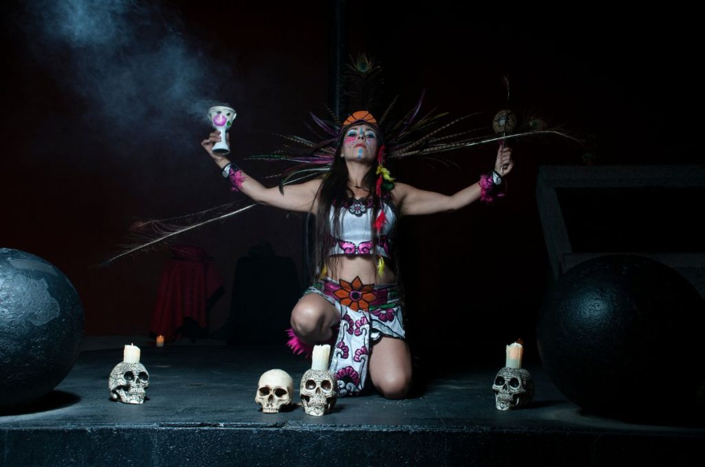 Actriz en atuendo prehispánico con calaveras