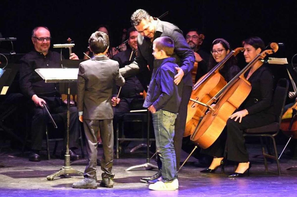 Niño interactuando en concierto sinfónico